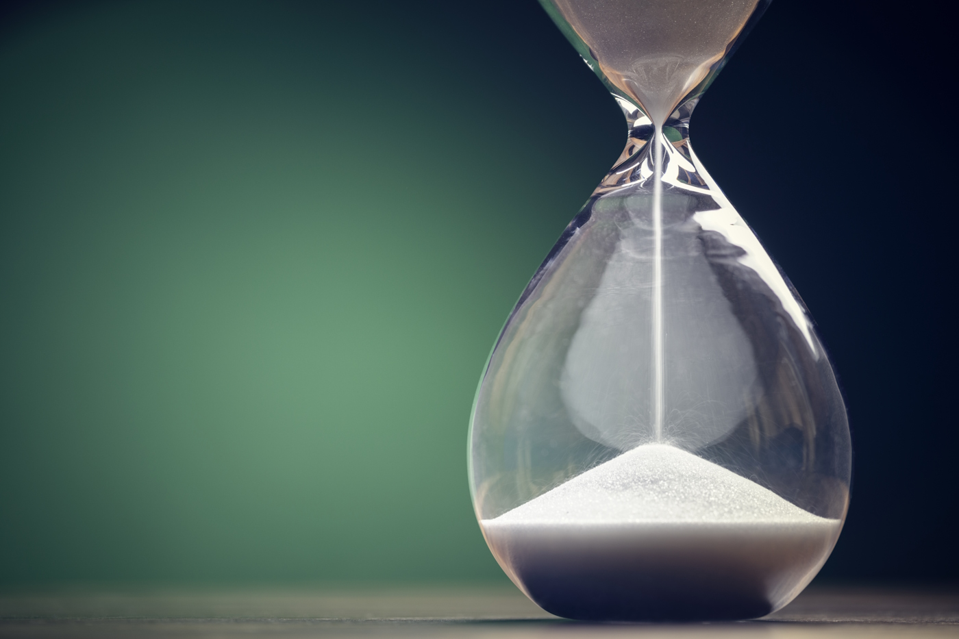 An hour glass on a green background